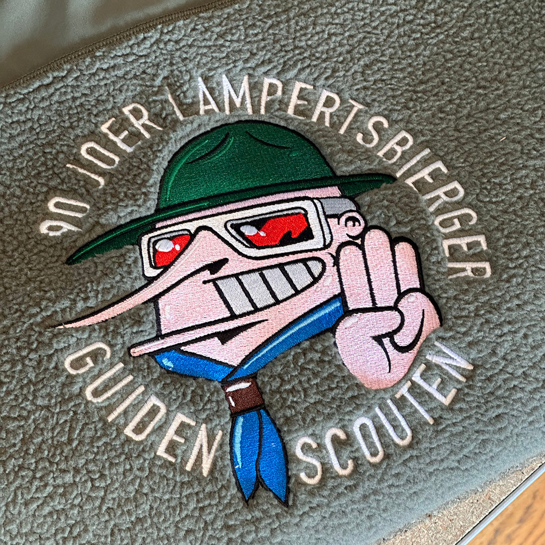 Embroidered patch on a textured surface with text and cartoon character design.